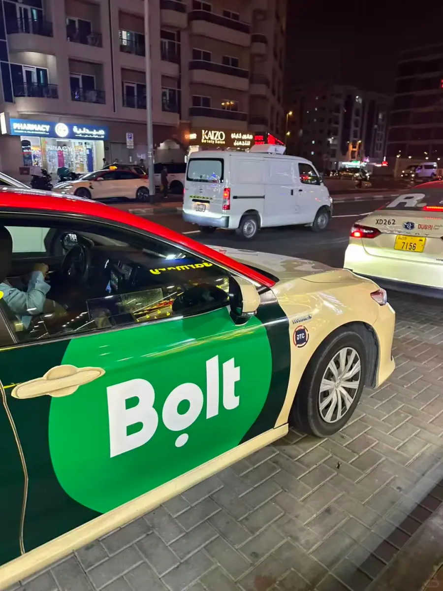 A Bolt car parked at night, its green livery easy to spot