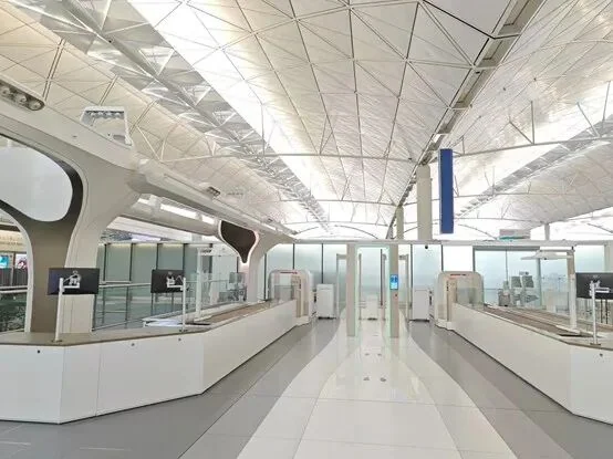 The wider security area at Hong Kong International, with lanes and baggage screening equipment in sequence