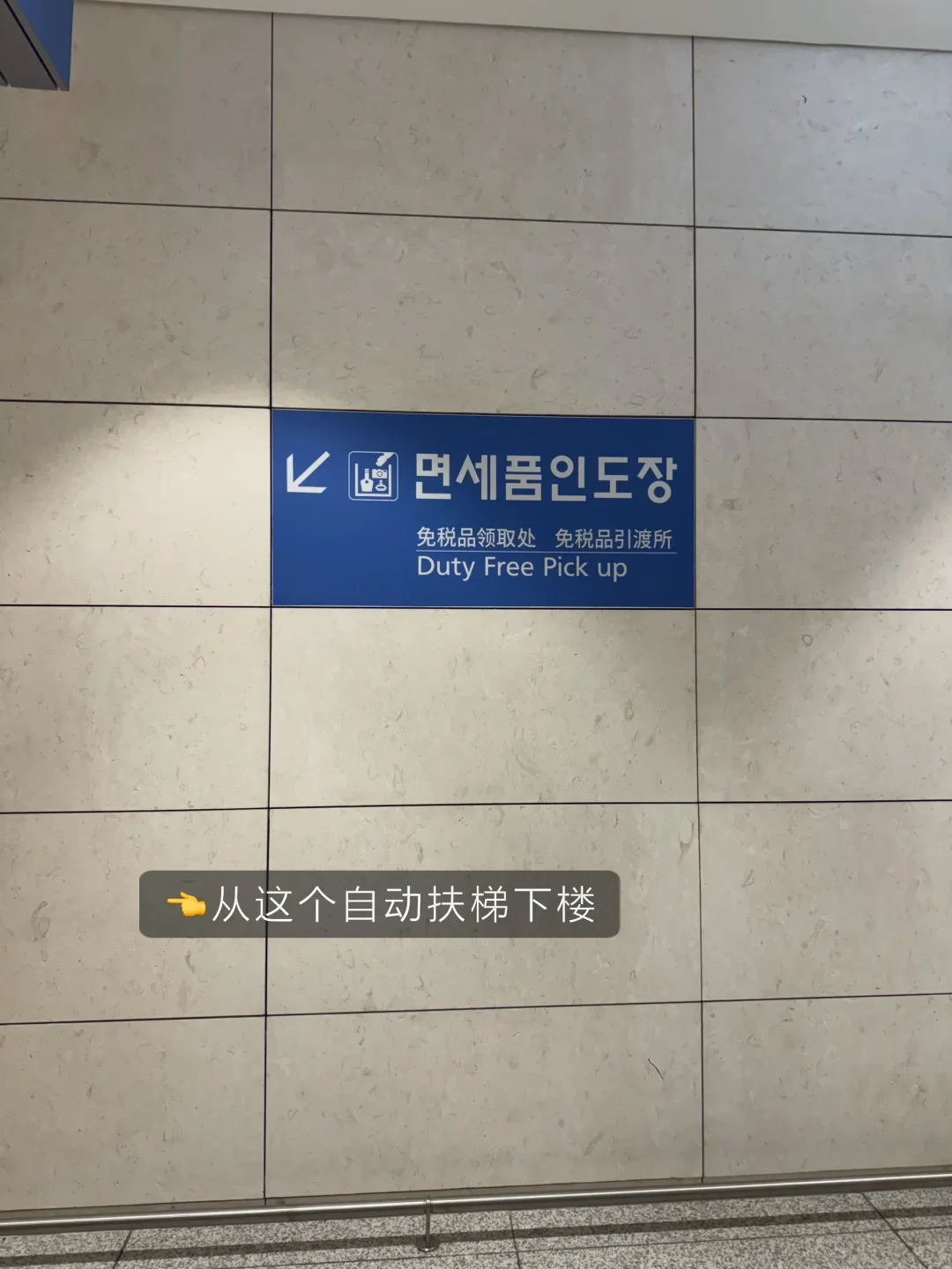 A wall sign on level 3 pointing down the escalator to the collection hall