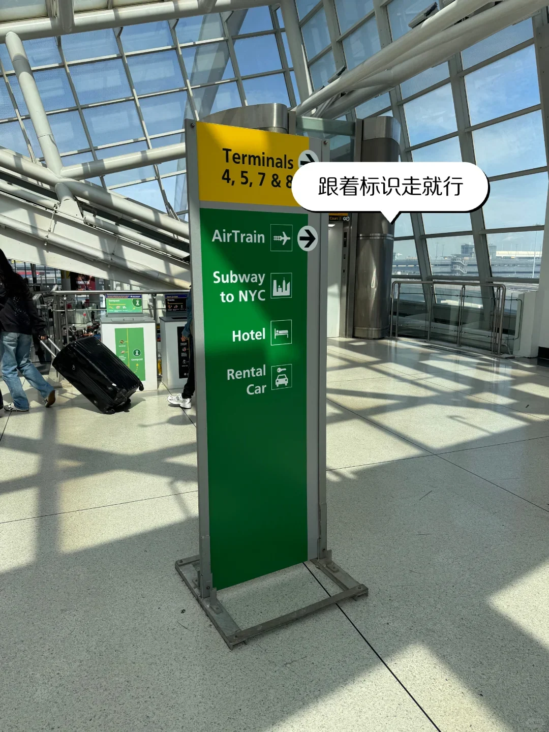 Signage at JFK Terminal 1 pointing to the AirTrain and the subway into New York