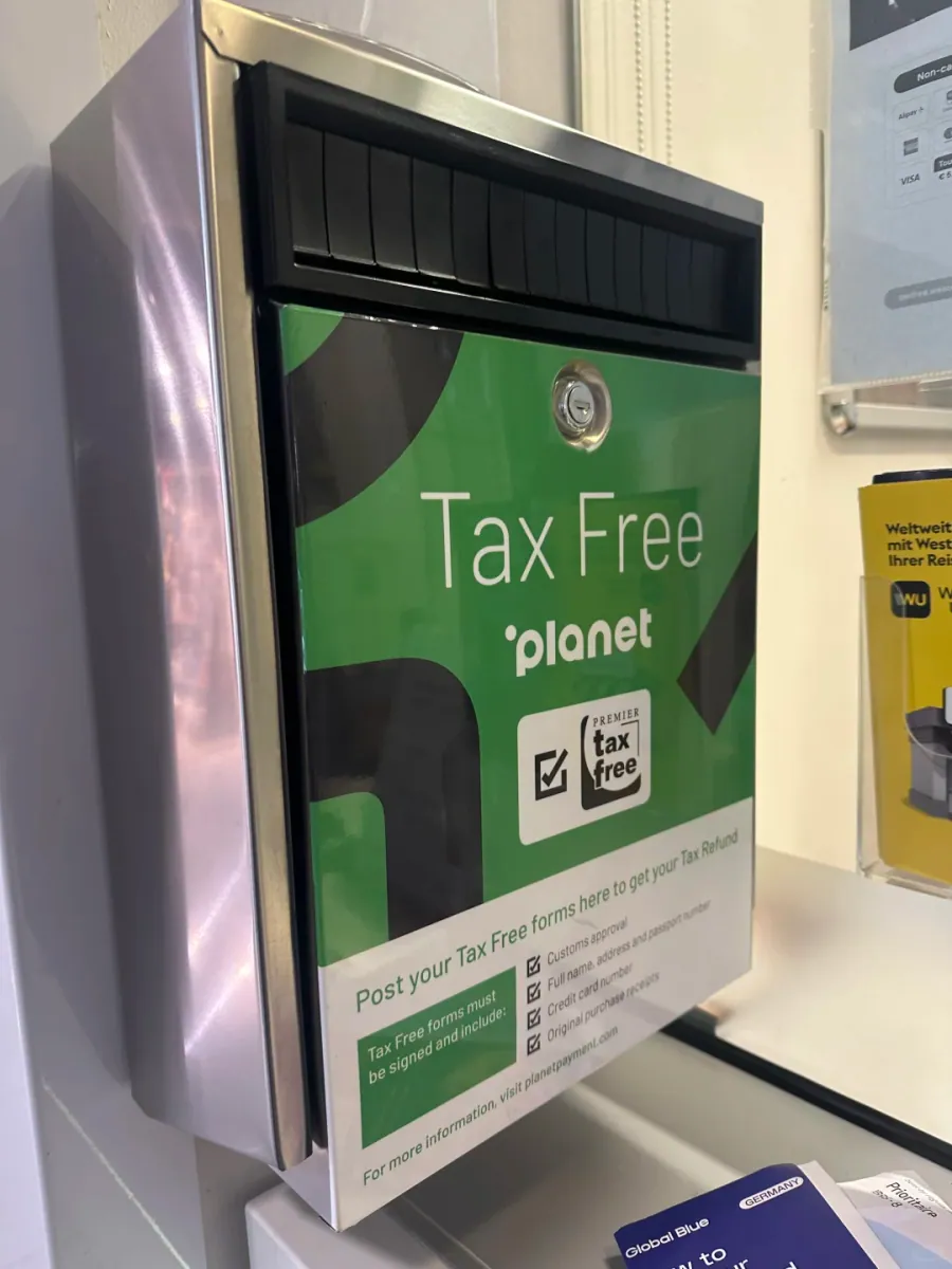 A green Planet Tax Free drop box mounted on the wall: a slot at the top, the Tax Free planet and Premier tax free logos, and a checklist for customs approval, name and passport number, card number and original receipt