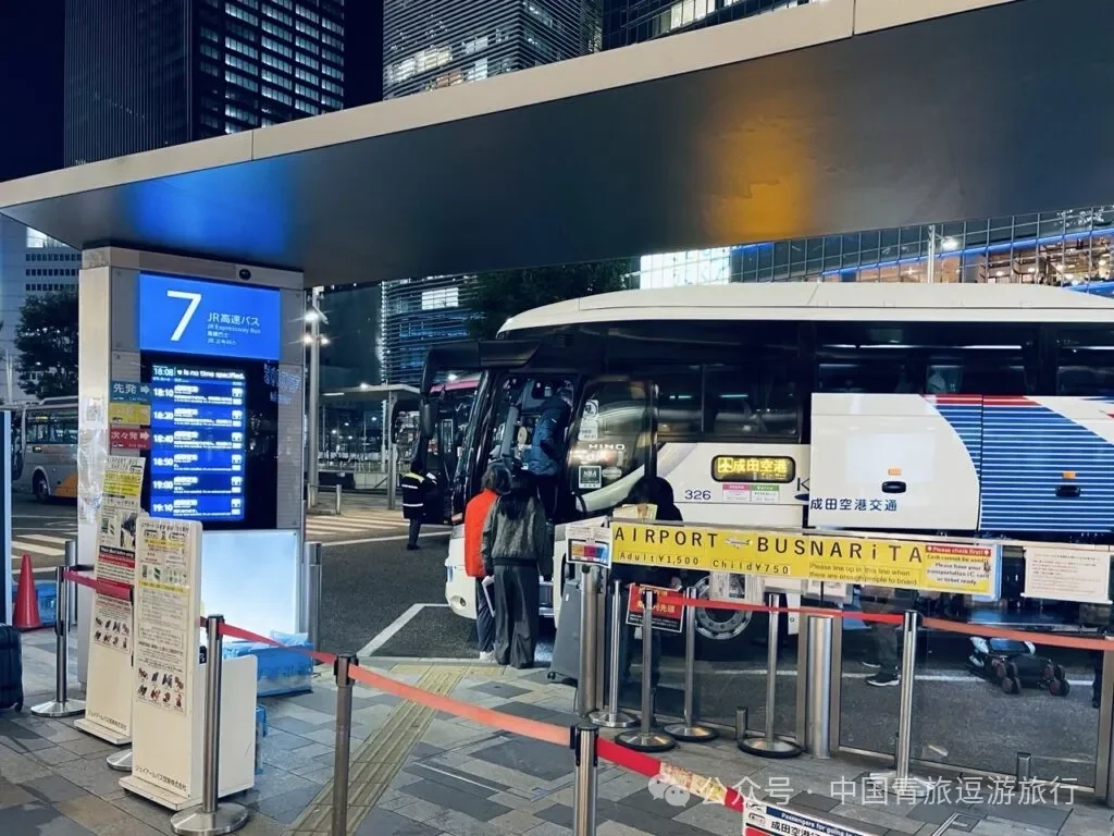 The number 7 bus stop at Tokyo Station's Yaesu South Exit, with passengers queueing for the airport coach at night