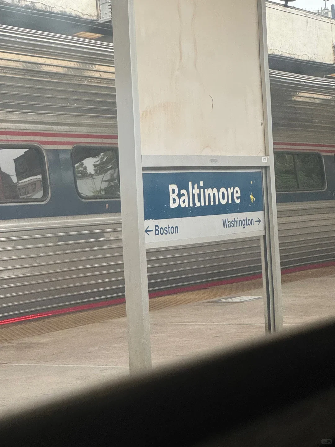 The train calling at Baltimore, with the sign pointing to Boston and Washington