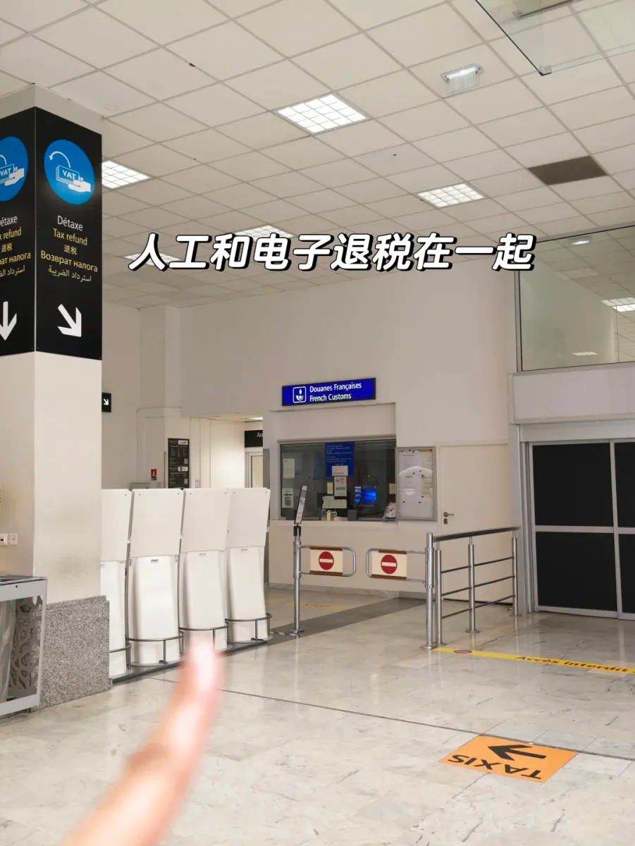 The arrivals hall in Terminal 1: a black pillar sign reading Détaxe / Tax refund in five languages points towards the French customs office, with a row of white self-service kiosks in front