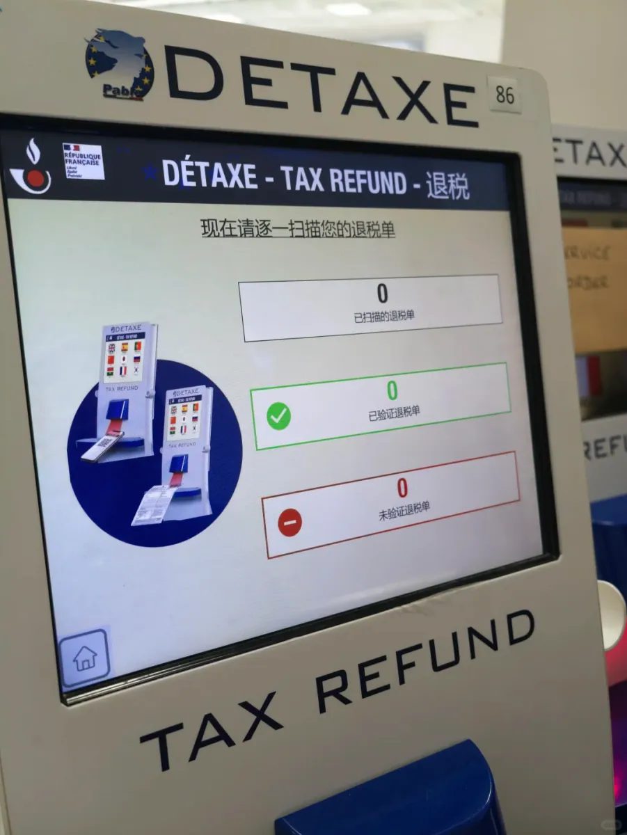The Chinese interface on a DETAXE screen: the header reads DÉTAXE - TAX REFUND - 退税, the prompt asks you to scan your refund forms one at a time, and three counters below show 0 scanned, 0 validated and 0 not validated, with a diagram of how to insert a form