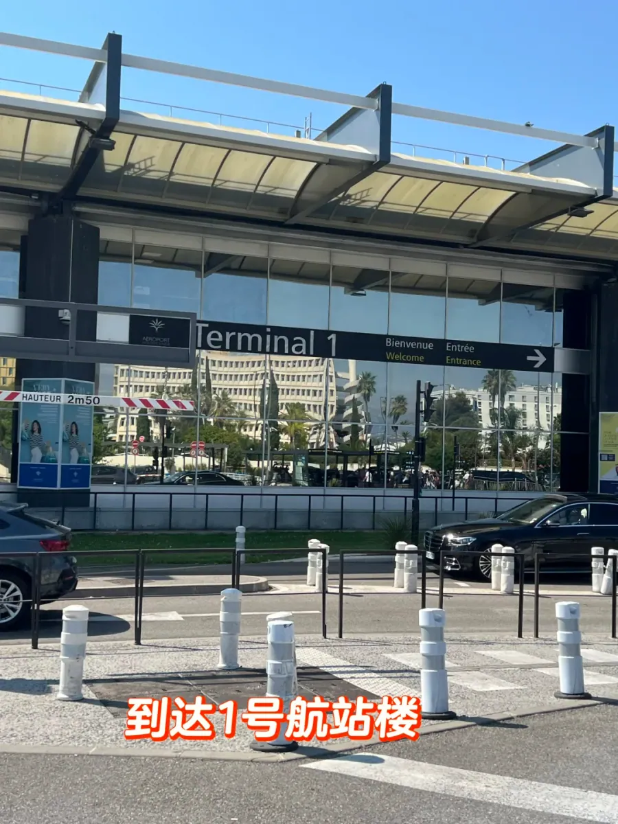 The drop-off lane at Nice airport Terminal 1: "Terminal 1" and "Bienvenue/Welcome" above the glass frontage, with cars parked at the kerb