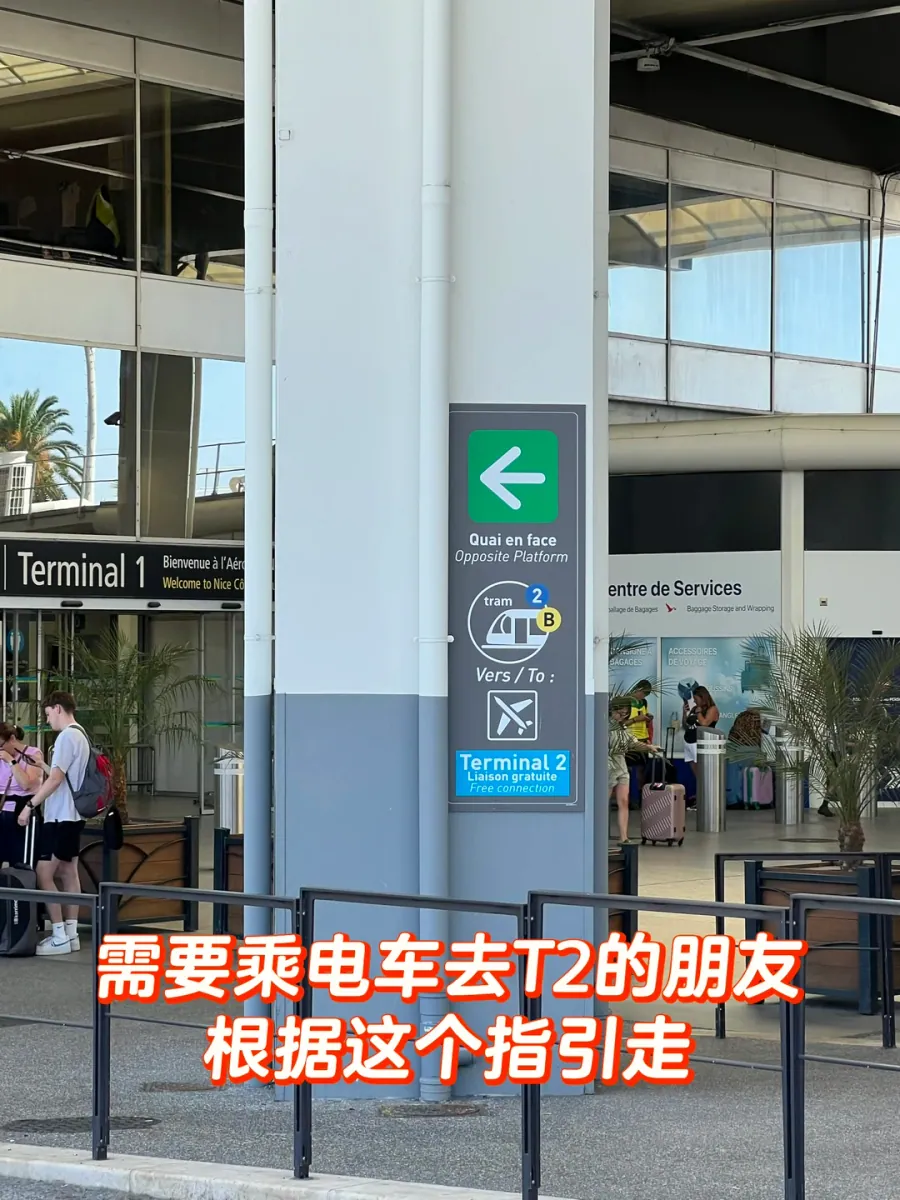 A pillar sign outside Terminal 1: a green arrow for "Quai en face/Opposite Platform", the tram 2/B symbol and "Terminal 2 — Liaison gratuite/Free connection"