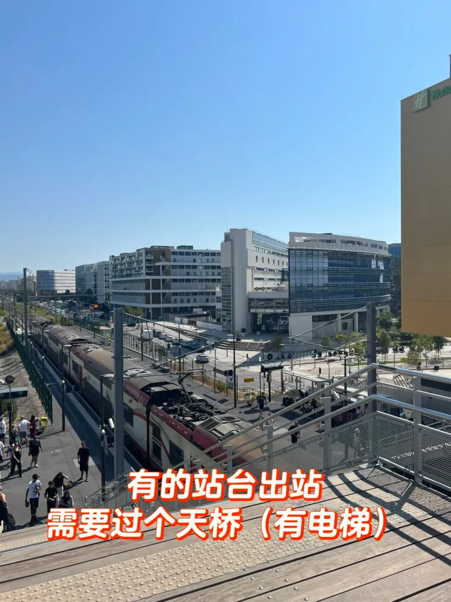 The view from the Saint-Augustin platform: tracks, overhead lines and airport buildings beyond, with a footbridge at the end of the platform