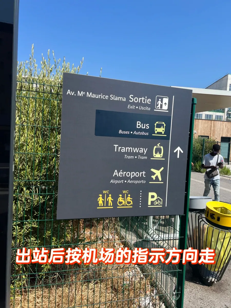 A dark grey sign outside Saint-Augustin station: Av. Me Maurice Slama, Sortie/Exit, and icons for bus, tram, airport, toilets and parking