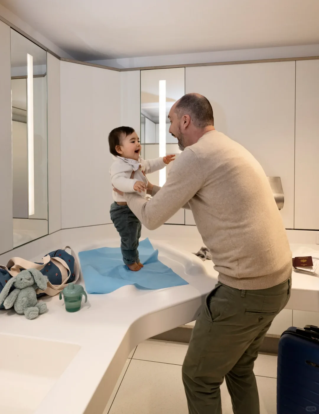 A baby-changing table in a Paris CDG nursery, where a father is changing his toddler