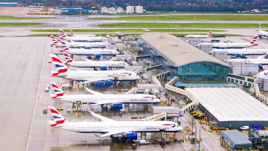 British Airways aircraft lined up at Heathrow stands, with terminal piers and the airfield behind