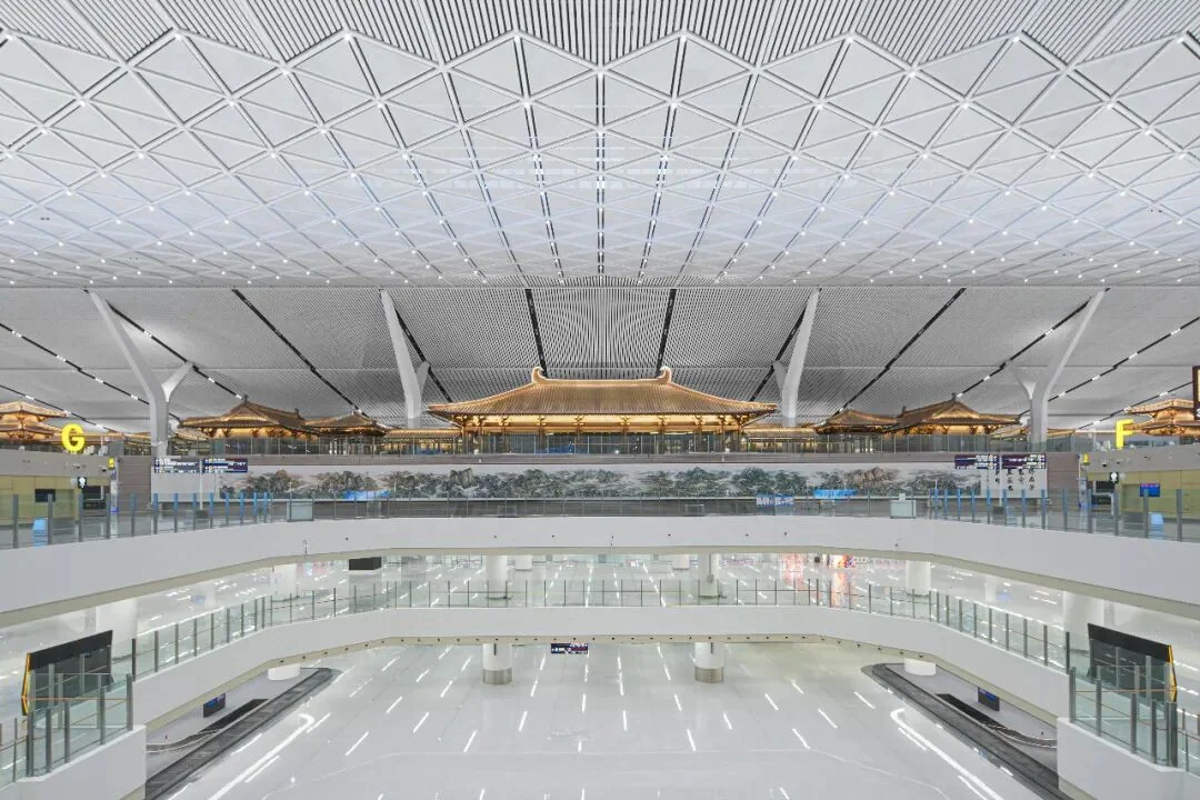 The departures hall, where hall-like pavilions and a painted ceiling sit beneath the roof