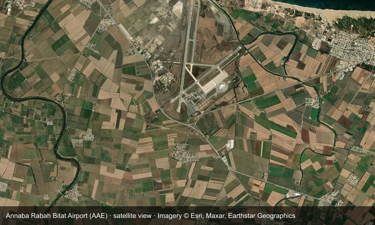 Satellitenansicht: Die Startbahnen von Annaba liegen zwischen Mittelmeerküste und Hügeln, Terminal und Vorfeld daneben.