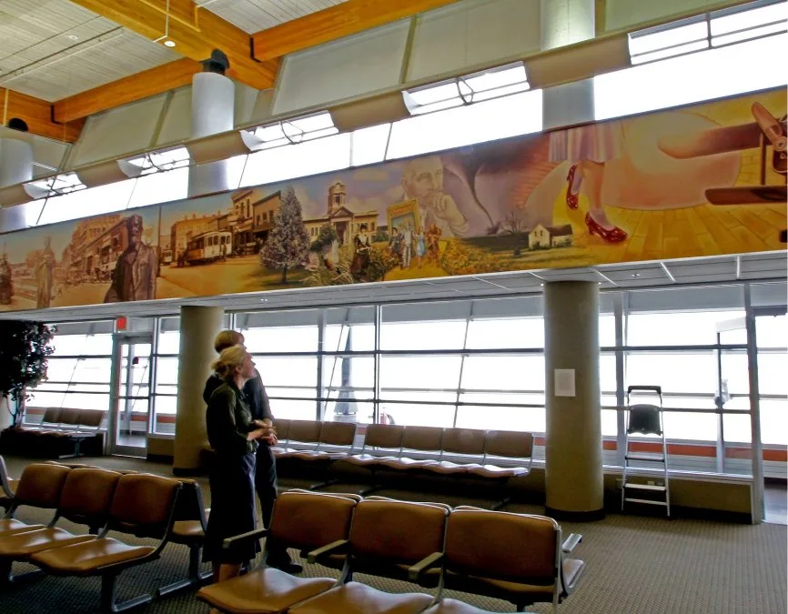 Das große Wandbild über dem Wartebereich — eine Straßenszene einer Präriestadt, über die ganze Wand gemalt, das auffälligste Merkmal des Terminals.