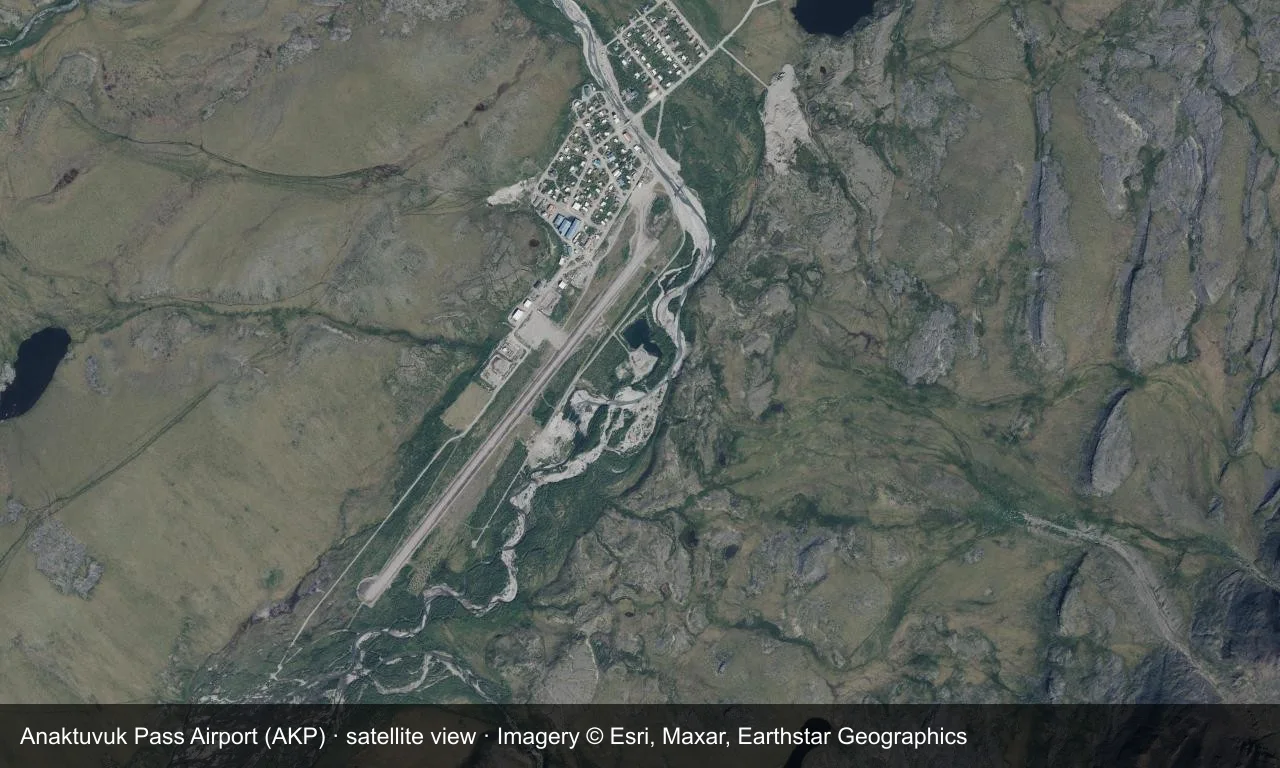Satellitenansicht: die Schotterpiste von Anaktuvuk Pass liegt in einem Tal der Brooks Range, Terminal und Vorfeld daneben.