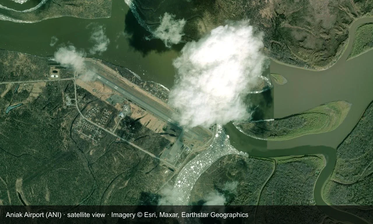 Satellitenansicht: Die Startbahn von Aniak verläuft entlang des Kuskokwim River, Terminal und Vorfeld daneben, Wald und Feuchtgebiete drumherum.
