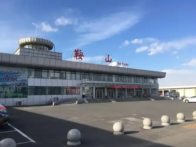 Die Front des Terminals von Anshan Teng'ao Airport – rote Zeichen „鞍山“ und die Beschriftung „An Shan“ auf dem Dach, darunter ein fast leerer Vorplatz.