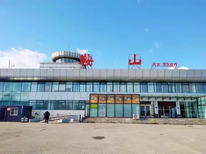 Ein näherer Blick auf das Terminal – Stufen und Laternen vor der verglasten Front, links der runde Kontrollturm.