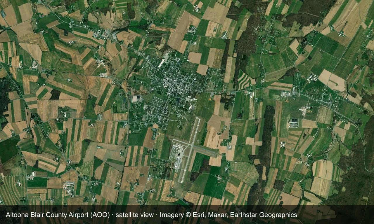 Satellitenansicht: Die Startbahnen von Altoona liegen zwischen Wald und Bergrücken der Alleghenies, Terminal und Vorfeld neben dem Feld.