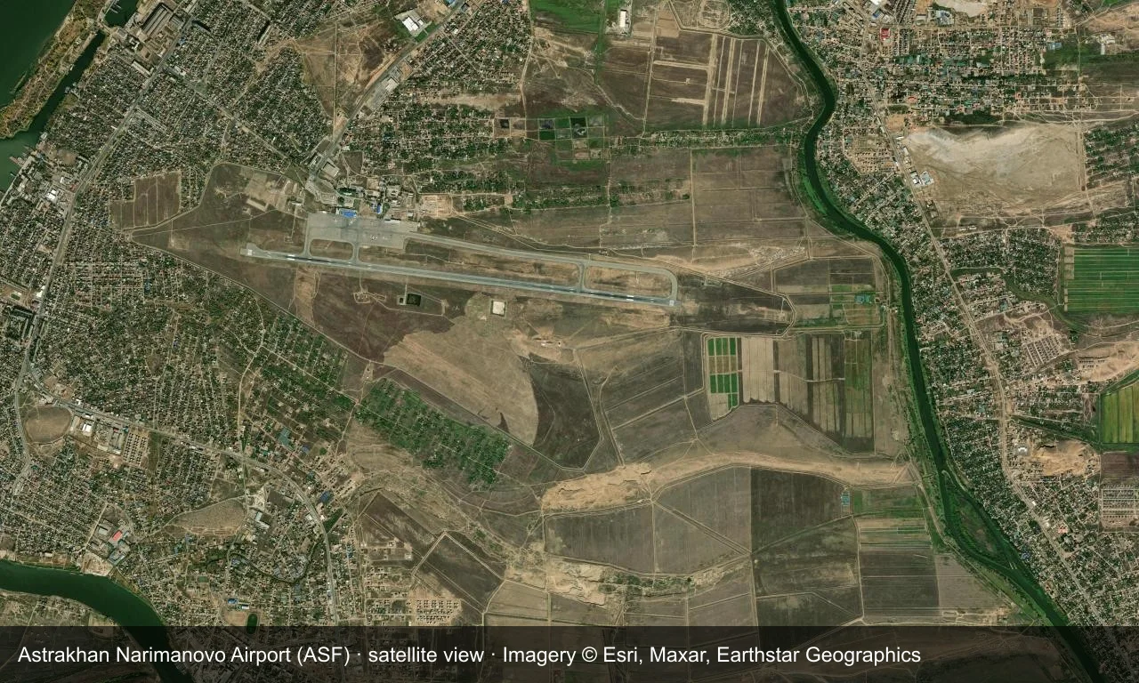 Satellitenansicht: Astrachans Startbahn liegt im Tiefland der unteren Wolga, mit Terminal und Vorfeld daneben und Wasserläufen und trockenem Land ringsum.