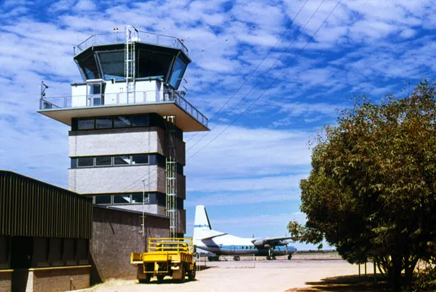 Der alte Kontrollturm von Alice Springs – ein Backsteinschaft unter der verglasten Kanzel, eine Fokker F.27 wartet auf dem Vorfeld (um 1970; Foto Terry Martin, CAHS-Sammlung, über das Airways Museum).