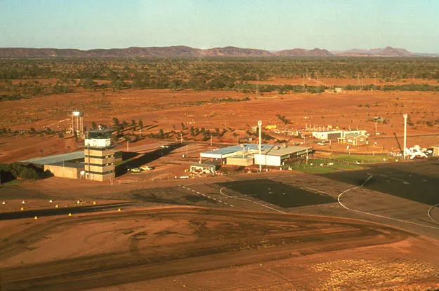 Alice Springs aus der Luft – Start- und Rollbahnen über roter Wüste, Turm, Terminal und Vorfeld entlang des Flugfelds (CAHS-Sammlung, über das Airways Museum).