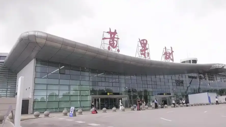 Das Terminal des Anshun Huangguoshu Airport, die roten Schriftzeichen „黄果树“ auf dem geschwungenen Dach, darunter ein fast leerer Vorplatz.