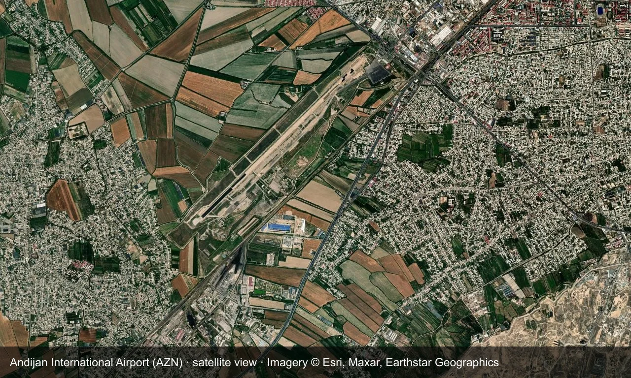 Satellitenansicht: Andijans Bahn liegt zwischen Ackerland und Stadt im Ferganatal, mit Terminal und Vorfeld daneben.