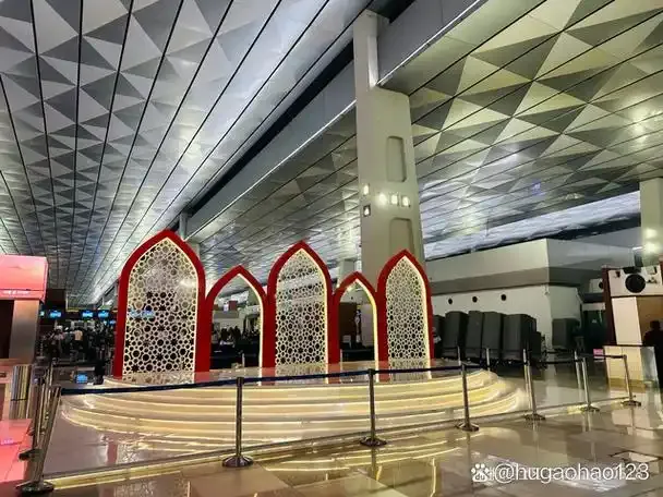 Im Terminal von Soekarno-Hatta – rote Bögen mit filigranem Muster unter der geometrischen Decke der Abflughalle.