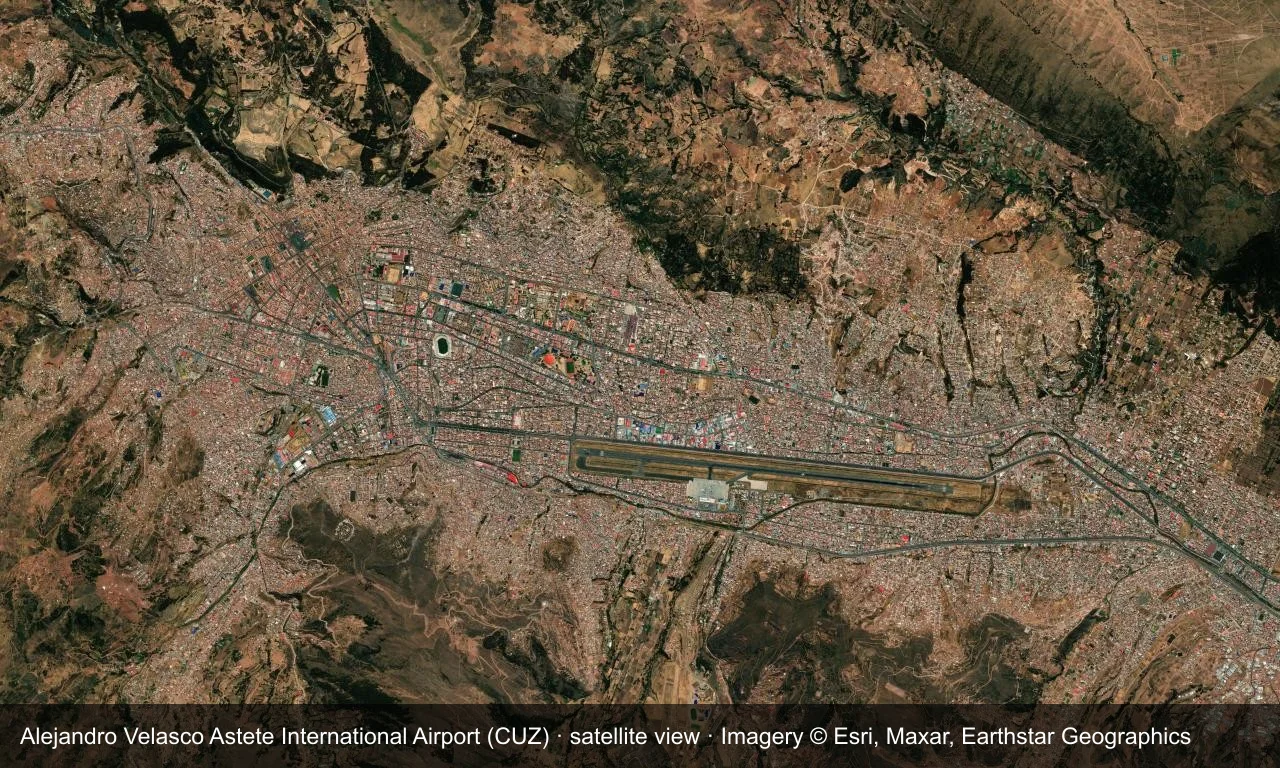 Satellitenansicht: Die Startbahn von Cusco liegt in einem Andental, Terminal und Vorfeld daneben, ringsum Stadt und Hänge.