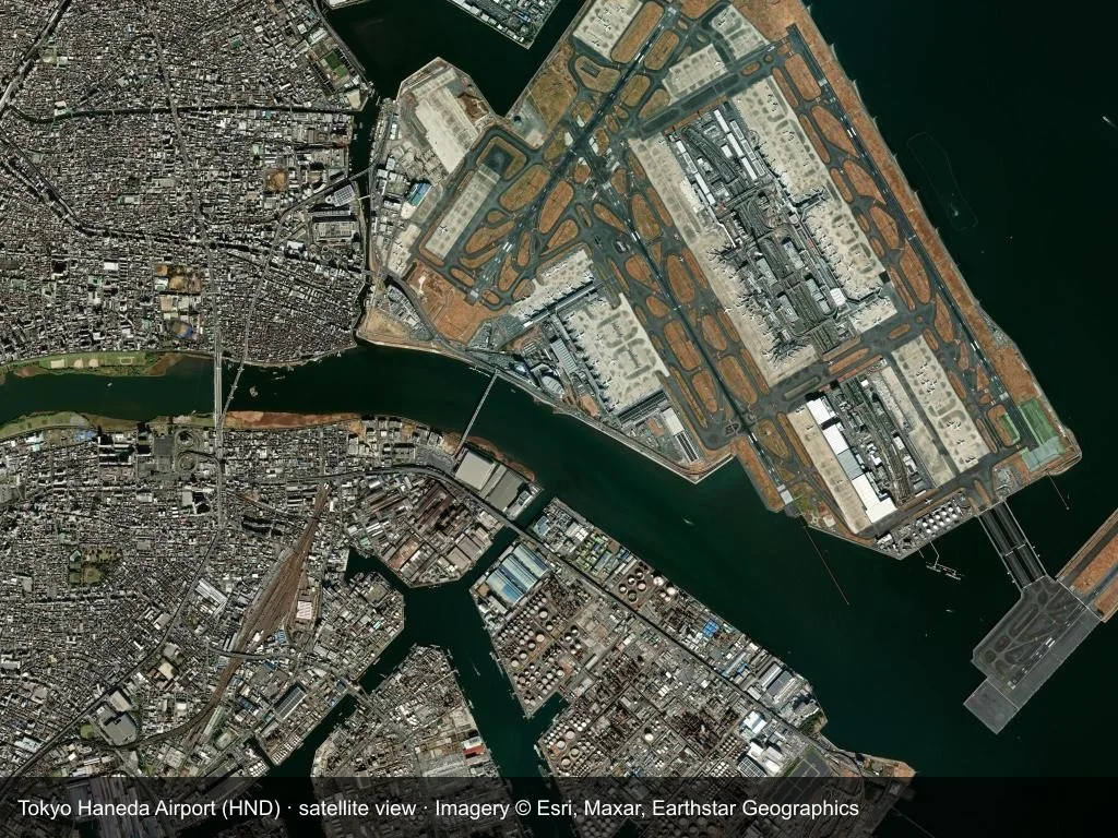 Satellitenansicht: Der Flughafen Tokio Haneda (HND) liegt eingebettet in Stadt, Küste oder Gelände, die Startbahn durchquert das Bild.