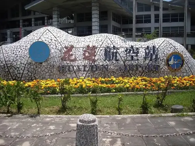 The flower-lined stone wall at Hualien Airport's entrance, lettered "Hualien Airport".