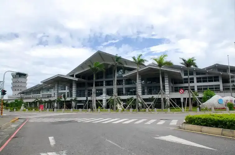 The front of Hualien Airport's terminal, with palm trees along the glass facade and the control tower at left.