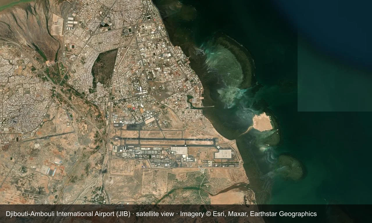 Satellitenansicht: Djiboutis Startbahn liegt am Südufer des Golfs von Tadjoura, mit dem Terminal und dem Vorfeld nördlich des Flugfelds und Hafen und Stadt ringsum.