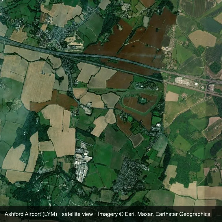 Das Flugfeld des Ashford Airport (LYM) aus dem Orbit, eingebettet in dichte grüne Vegetation und kleine Felder.