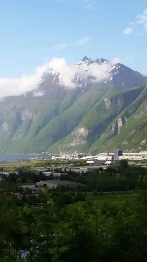 Der Flughafen zwischen Fjord und Bergen – seine Startbahn auf dem schmalen Streifen zwischen Wasser und Hang, Wolken ziehen über die Gipfel.