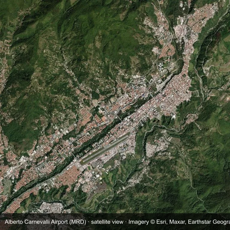Satellitenansicht: Alberto Carnevalli Airport (MRD) nimmt ein Stück dichter grüner Vegetation und kleiner Ackerflächen ein.