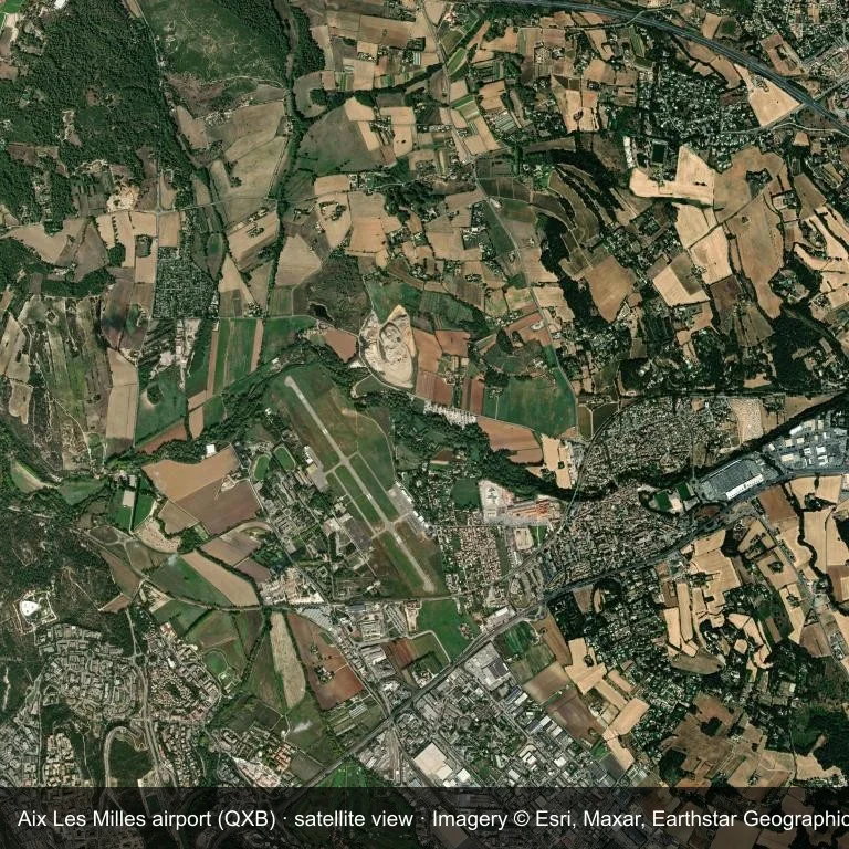 Satellitenansicht: Aix Les Milles airport (QXB) belegt einen Flecken grüner Vegetation und Ackerland.