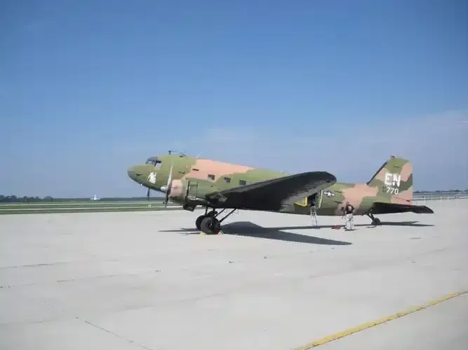 Eine C-47-Transportmaschine auf dem Vorfeld in Springfield, Propeller und Militärmarkierungen deutlich sichtbar.