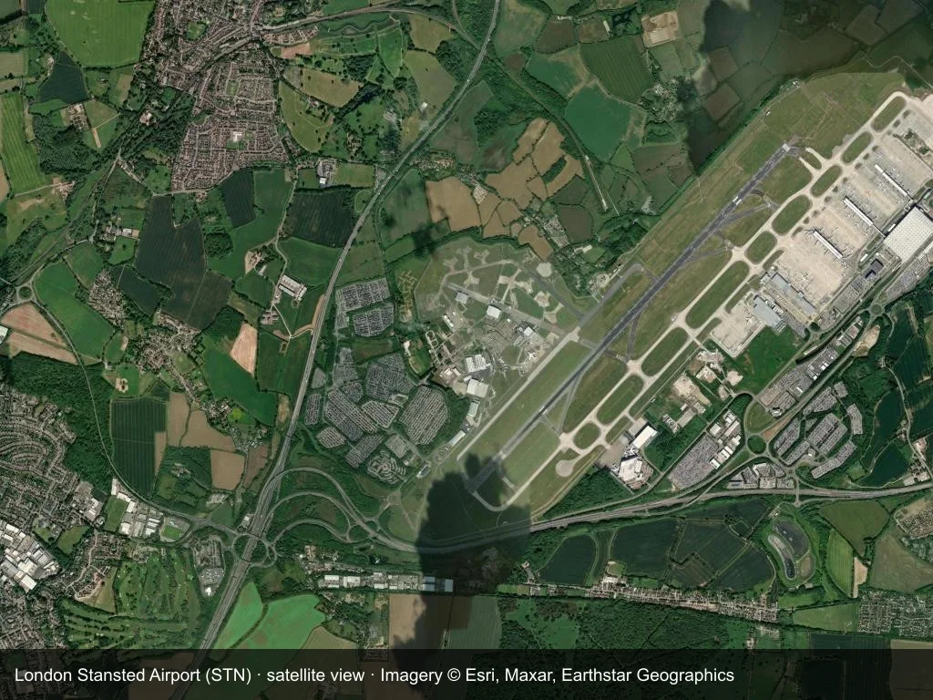 Auf dem Satellitenbild liegen die Terminals und Startbahnen des Flughafens London Stansted (STN) im Stadt- und Straßennetz.