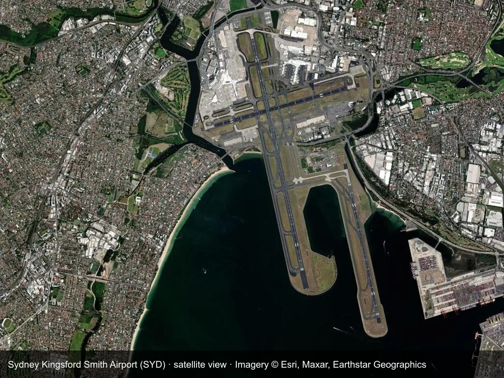 Satellitenansicht: die Terminals, Startbahnen und die umgebende Stadt am Flughafen Sydney (SYD).