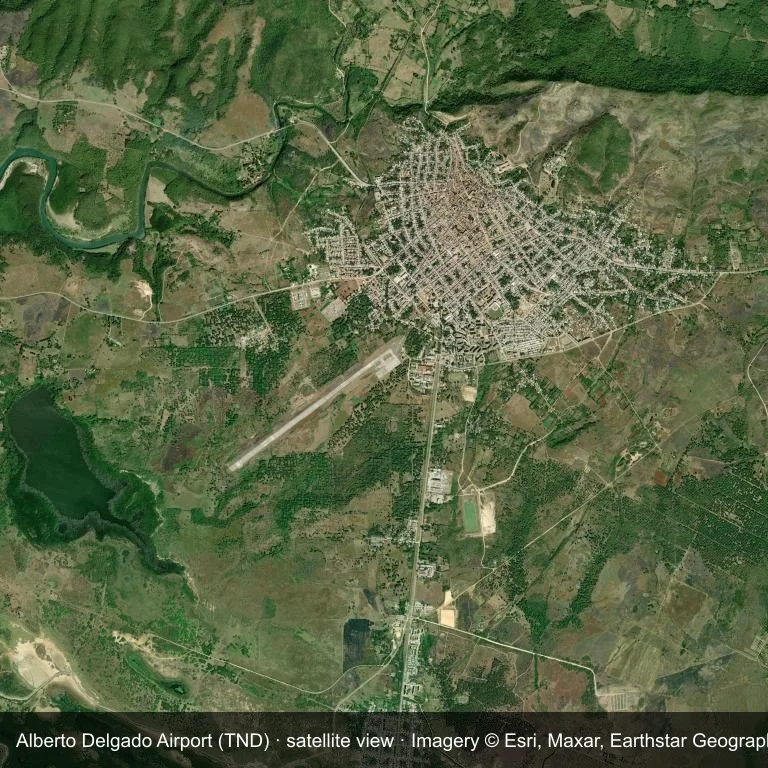 Aus der Umlaufbahn betrachtet erscheint Alberto Delgado Airport (TND) als ein Flugfeld in dichter grüner Vegetation und zwischen kleinen Feldern.