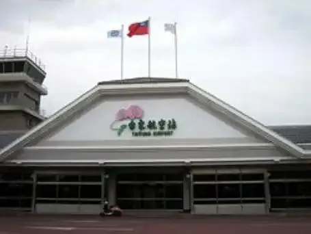 Taitung Airport's terminal with its triangular gable and green sign, with the control tower at left.