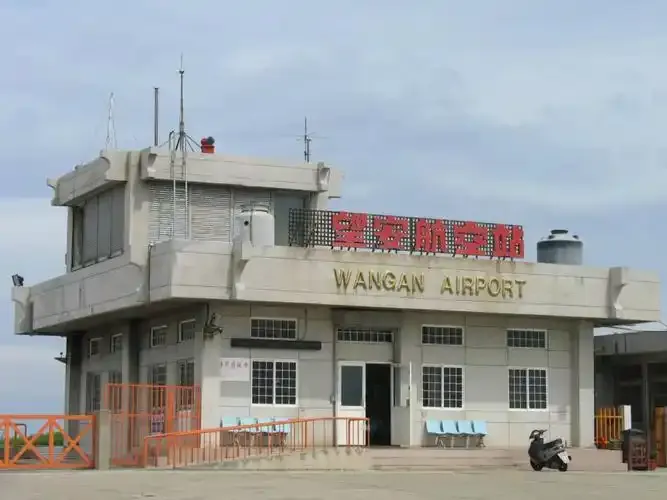 Wang'an Airport's compact terminal and rooftop control tower, with the 'Wang'an Airport' sign on its wall.