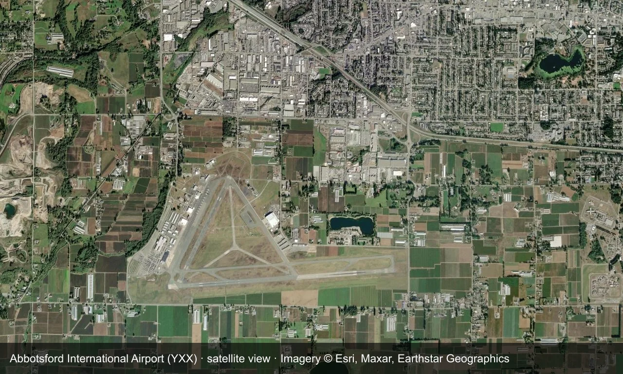Satellitenbild: die Startbahnen von Abbotsford liegen zwischen Ackerland und Bergen im Fraser Valley, mit Terminal und Vorfeld neben dem Platz.